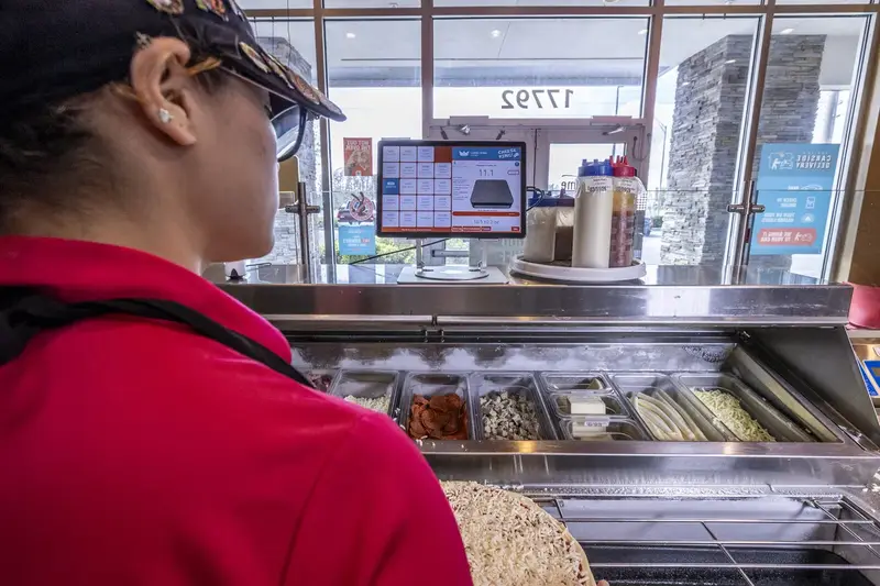 Staff member working the prep line in front of the Portion King scale display
